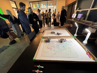 Visitors interacting with the drawing robots
