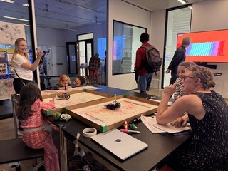 Children and adults using drawing robots at the V&A Digital Design Weekend